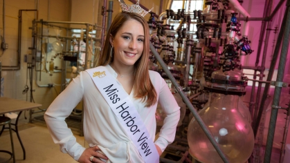 Smiling long light brown hair female New Jersey contestant wearing a crown and white Miss Harbor View sash