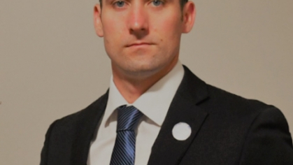 headshot of male student wearing a dark suit and tie