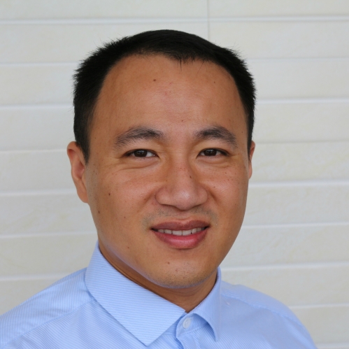 headshot of Asian male with short dark hair wearing a blue buttoned shirt