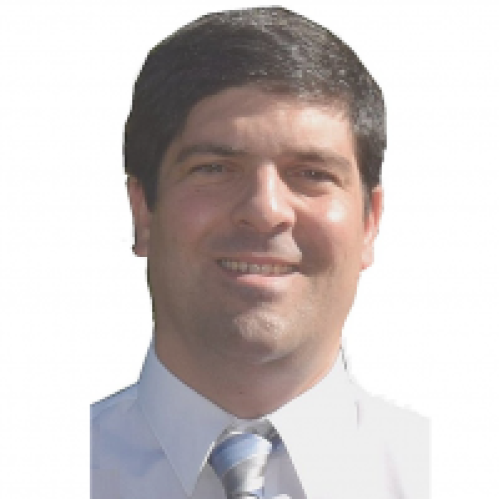 headshot of man with short dark brown hair wearing a white shirt with a tie