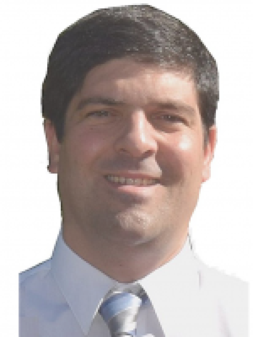 headshot of man with short dark brown hair wearing a white shirt with a tie
