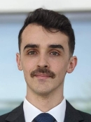 headshot of young male with a moustache in suit and tie