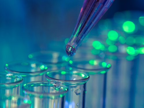 Dropper dispensing liquid into a row of test tubes