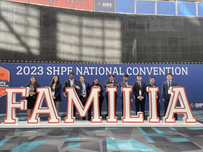 Ten students stand behind Familia sign at the 2023 SHPE National Convention.